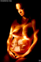 Pregnant nude with projected ultrasound. Light painted photograph.