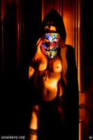 Female figure nude with cloak and mask. Light painting photograph.