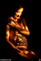 Pregnant figure nude with projected ultrasound. Light painted photograph.
